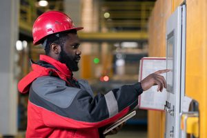 A fire alarm specialist in uniform checking the fire alarm system panel.